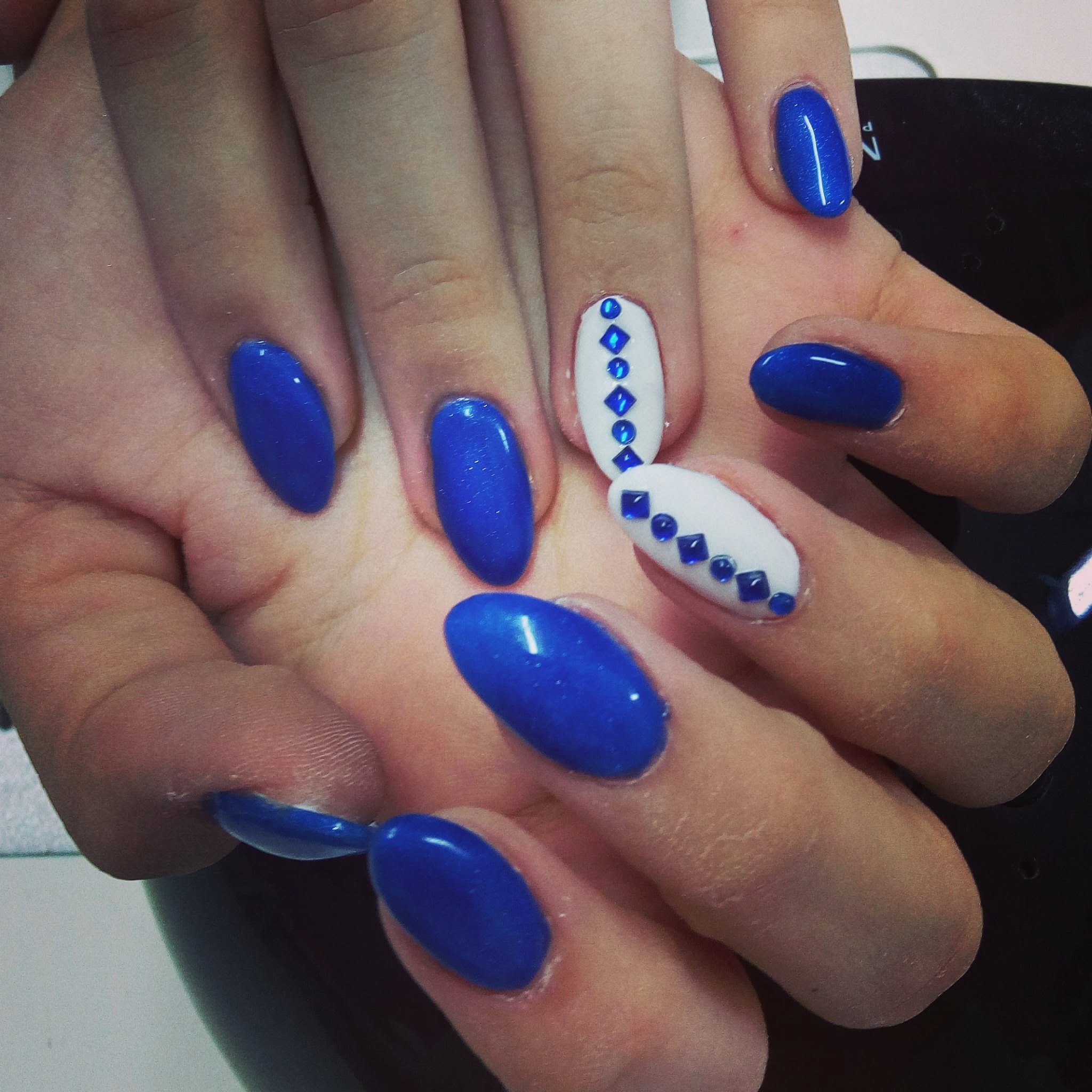 Unghie blu elettrico con strass su base bianca